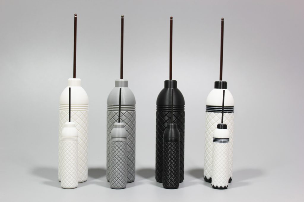 A collection of two-tone FDM 3D printed bottles in black, white, and gray, demonstrating the advanced dual-color printing capabilities and color options available through our 3D printing services